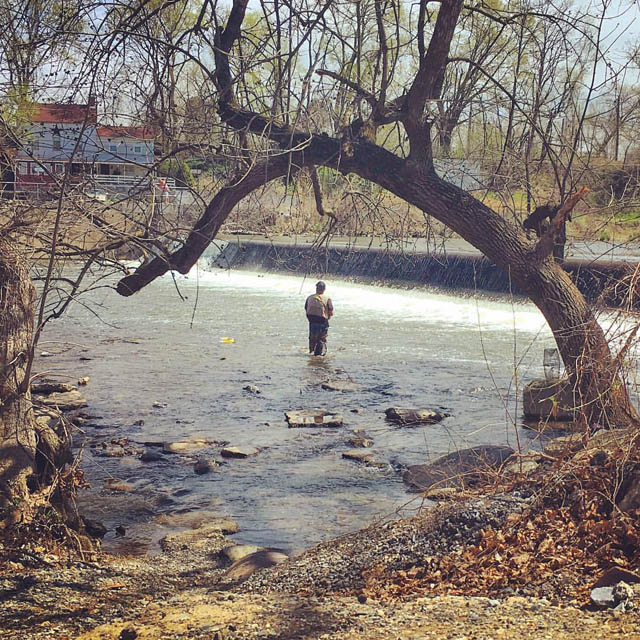 a person standing in the river run fishing